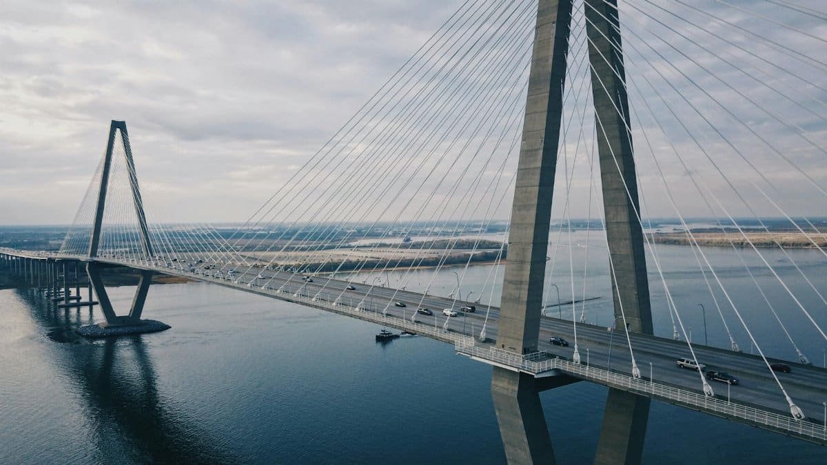 Drone shot highlighting the modern cable-stayed Arthur Ravenel Jr Bridge in South Carolina over tranquil waters.