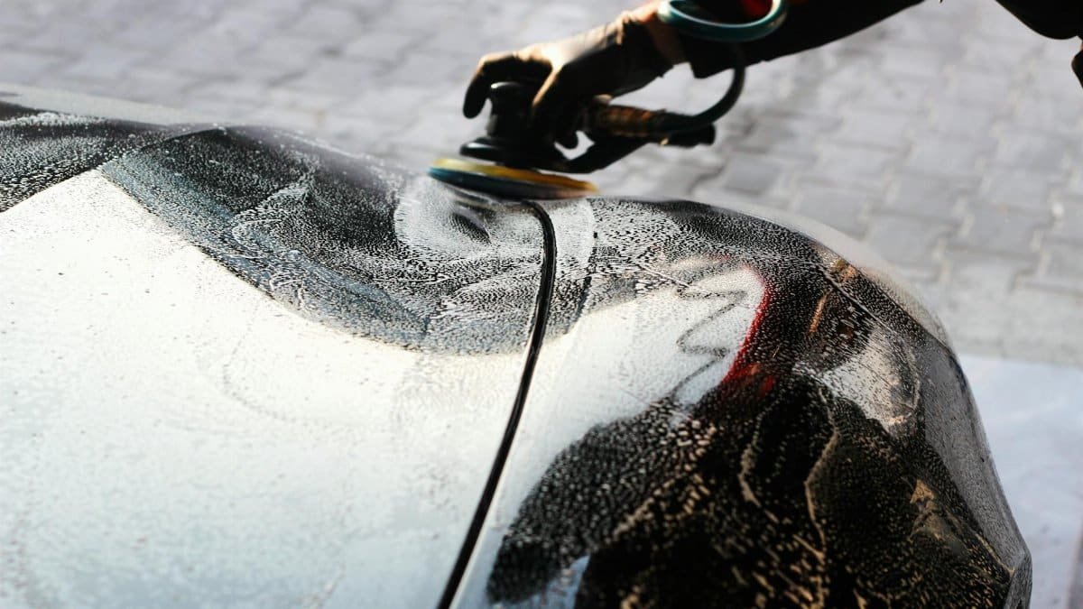 Close-up of a car being polished by hand, showcasing professional detailing and maintenance.