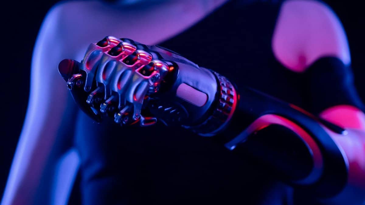 Close-up of a robotic prosthetic hand in neon lighting, symbolizing advanced technology.