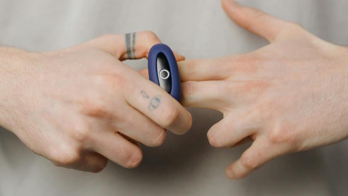 Hands applying a blue silicone ring in a detailed close-up shot.
