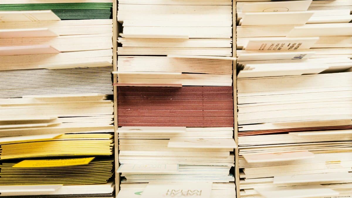 Close-up view of stacked documents in various colors organized in a file system.