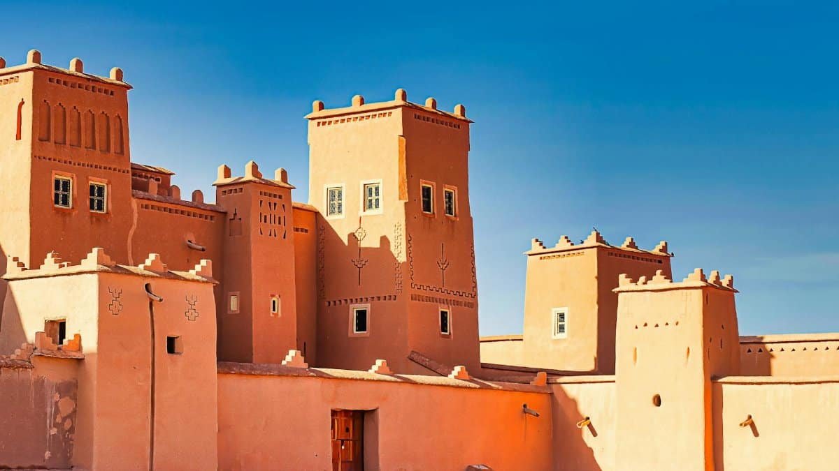 A stunning view of a traditional Moroccan fortress with distinct architectural features against a bright blue sky.