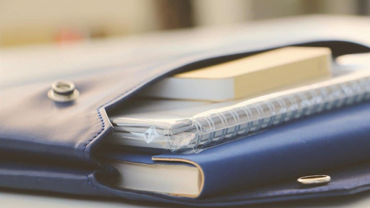 Close-up of a stylish blue portfolio containing various notebooks, creating an organized office look.
