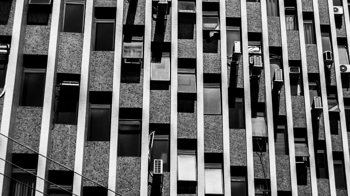 Monochrome image of a modern city building showcasing repetitive patterns and contrasts in architecture.