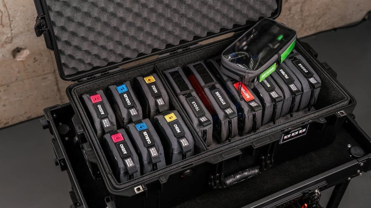 Open black hard case with labeled compartments showcasing professional gear and tools for organized storage.