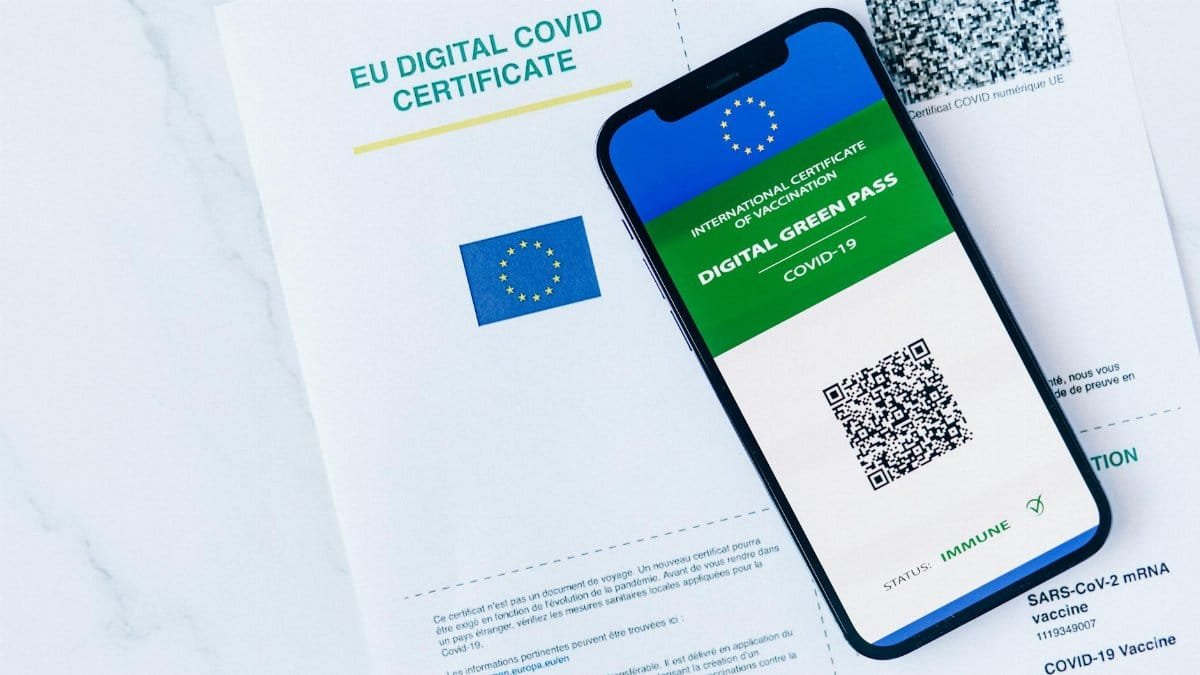 EU Digital COVID Certificate displayed on smartphone and paper form, vaccination proof.
