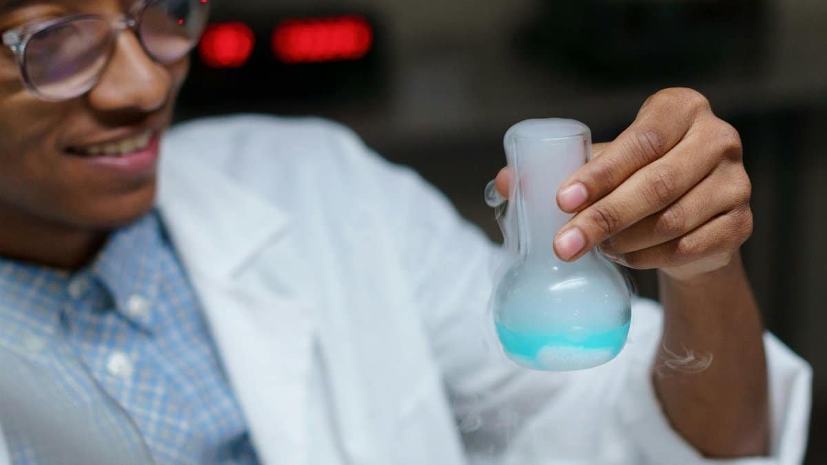 Close-up of a young scientist examining a chemical reaction in a laboratory.