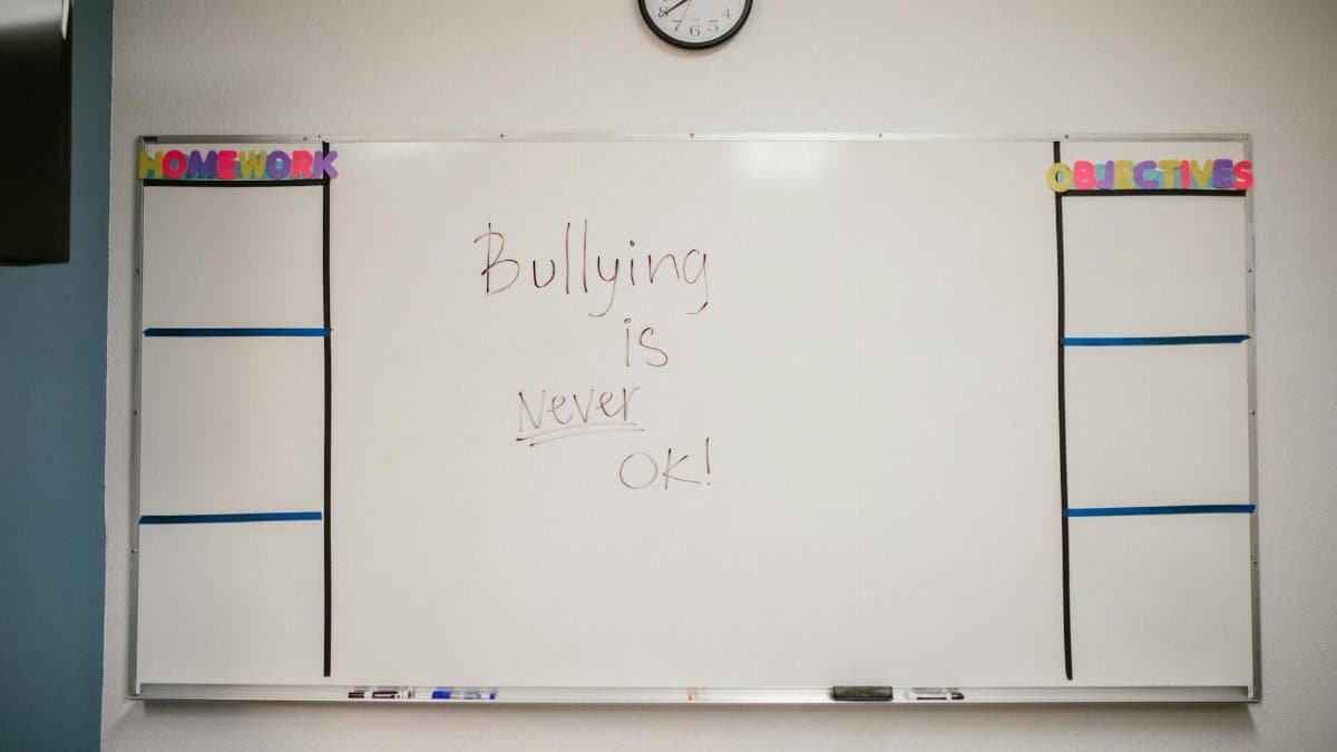 Whiteboard in classroom with 'Bullying is Never OK' message promoting awareness.