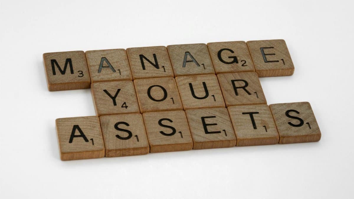 Wooden tiles spelling 'Manage Your Assets' offer conceptual business advice.