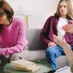 A couple undergoing therapy, expressing emotions on a sofa in a counseling office.