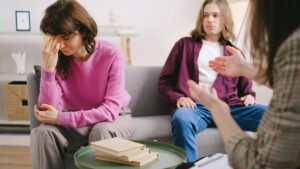 A couple undergoing therapy, expressing emotions on a sofa in a counseling office.