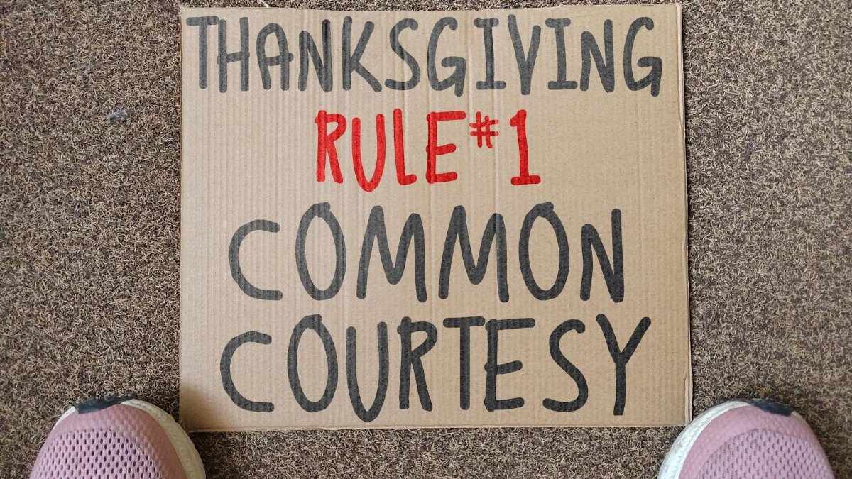 Cardboard sign with Thanksgiving Rule #1 written, promoting common courtesy.