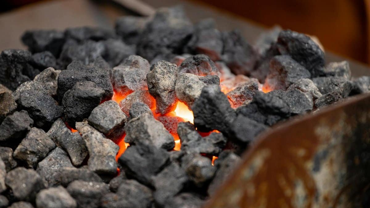 Intense close-up of glowing charcoal, radiating heat and vivid orange hues.