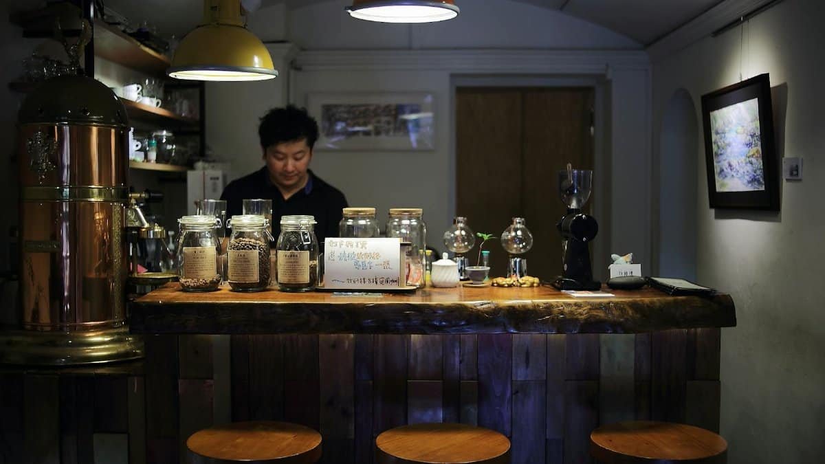 Warm, inviting coffee shop interior with barista preparing beverages behind a counter.