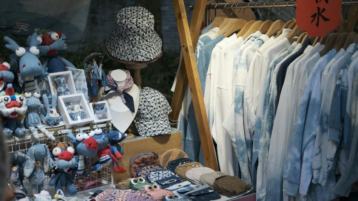 A vibrant stall featuring handmade crafts and clothing displayed neatly.