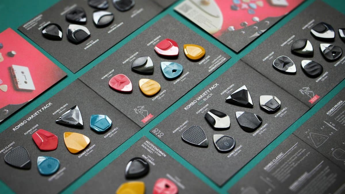 A variety of colorful guitar picks displayed on labeled cards in a top view layout.