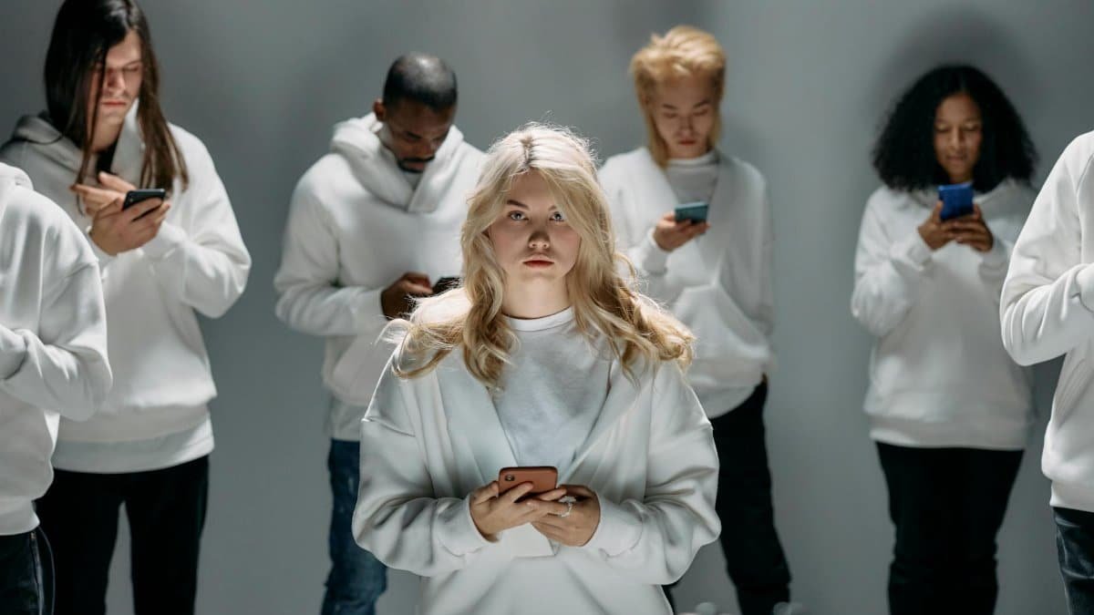 Diverse group of individuals engaging with smartphones, symbolizing modern digital connection and technology.