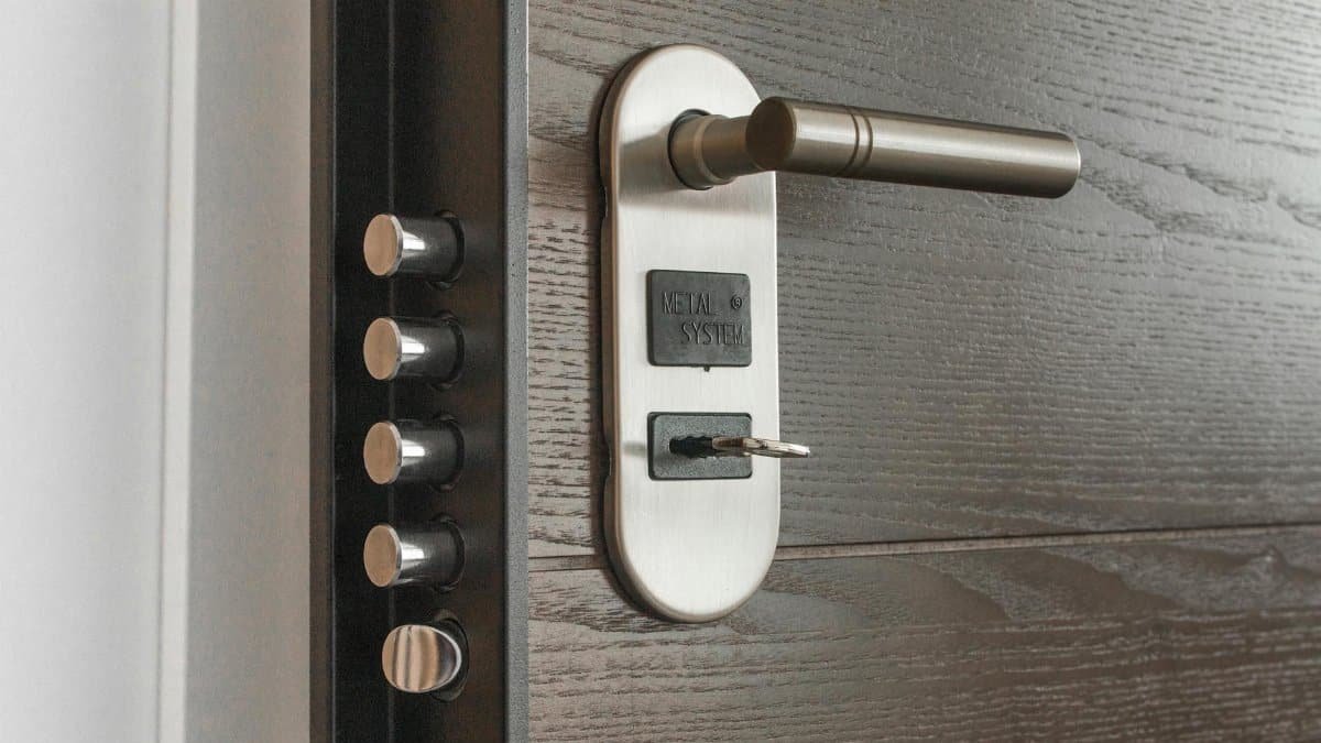 Metal door handle and lock system with key inserted, showcasing security features.