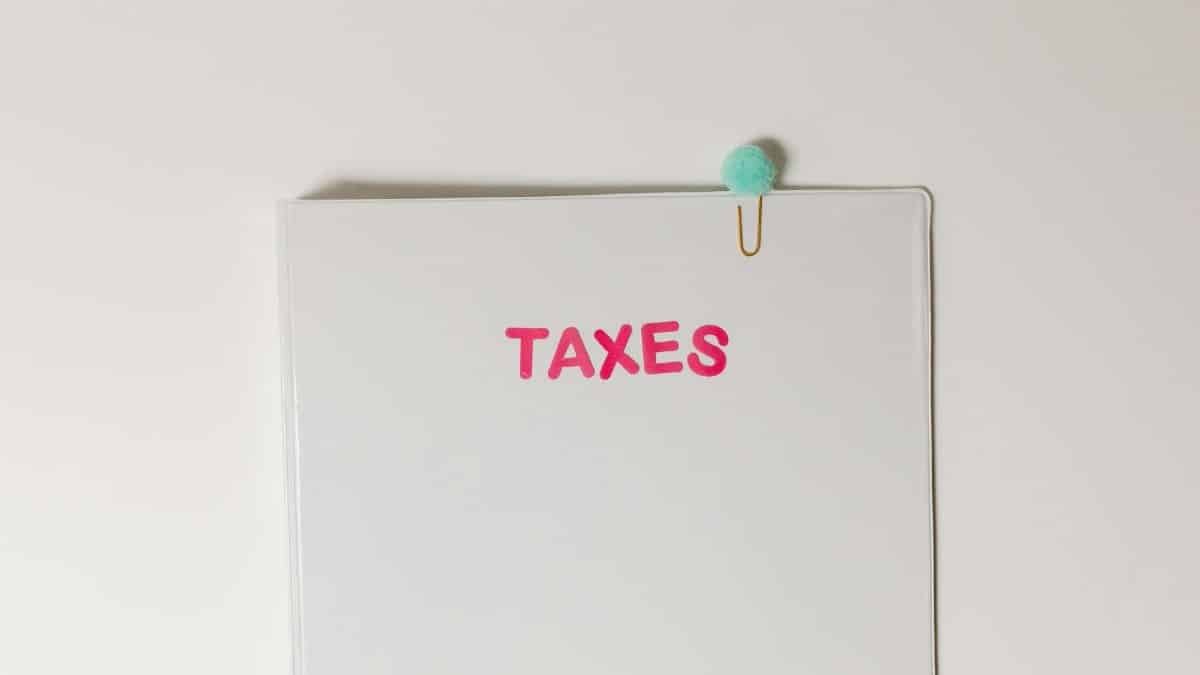 Close-up of a tax file with a pink 'TAXES' label and a paperclip, offering copy space and a conceptual minimalist design.