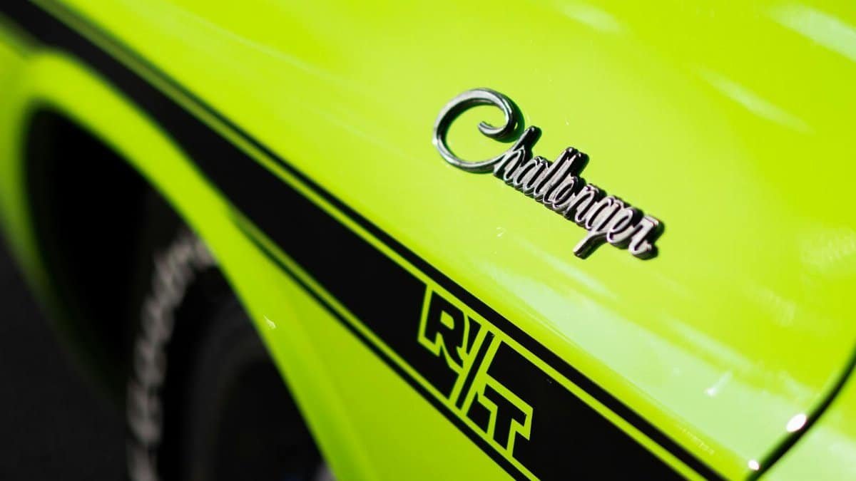 Close-up of a vibrant green Dodge Challenger RT emblem, showcasing retro design and dynamic style.