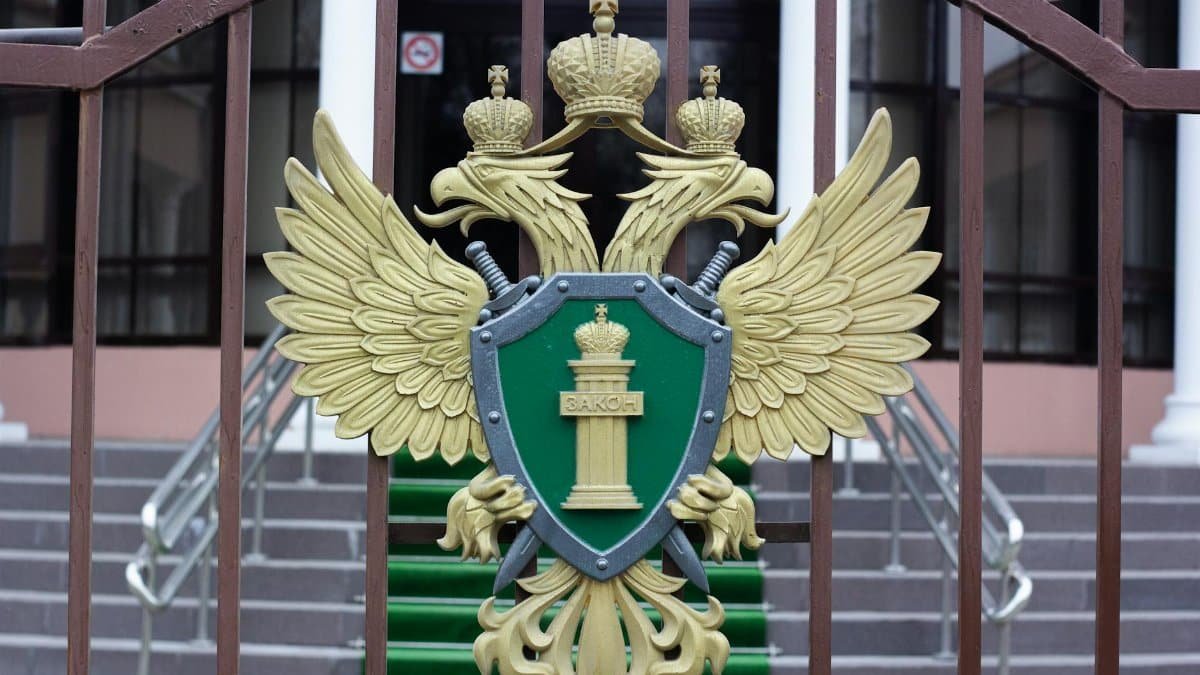 Close-up of a golden emblem with a double-headed eagle on an iron gate, signifying luxury and authority.