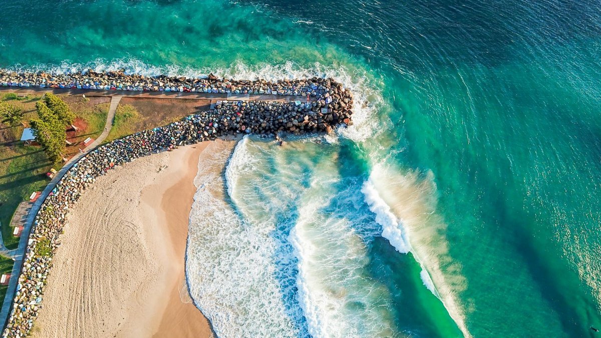 Breathtaking aerial view of waves crashing on Port Macquarie coastline in NSW, Australia.