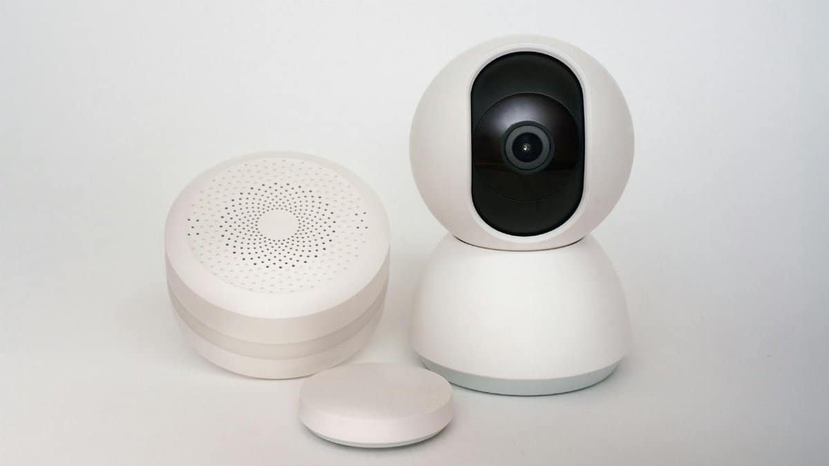 Modern minimalist smart home devices including security camera and sensors in white.