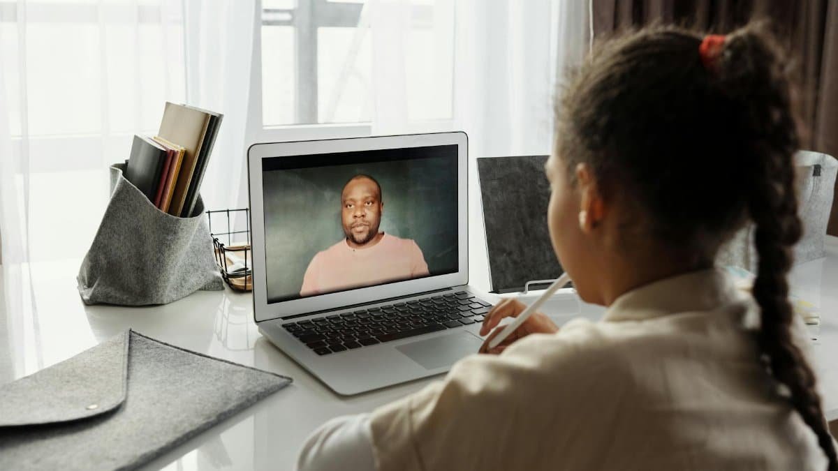 Child attending an online lesson at home via laptop. Remote education.
