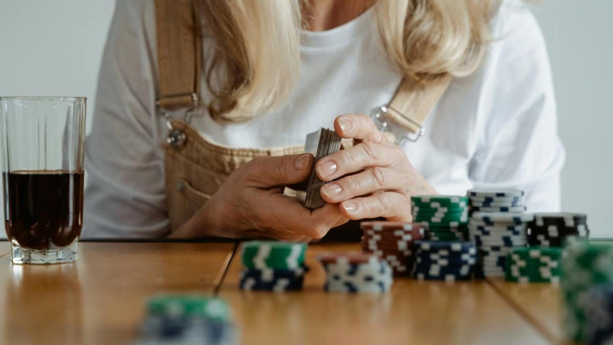 Elderly woman engaging in a poker game with chips and cards, focused and concentrated.
