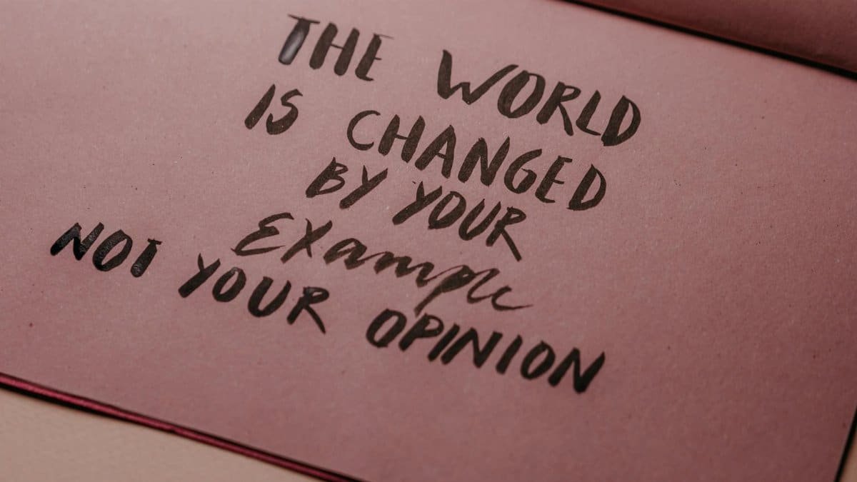 Motivational phrase emphasizing actions over words displayed on textured paper.