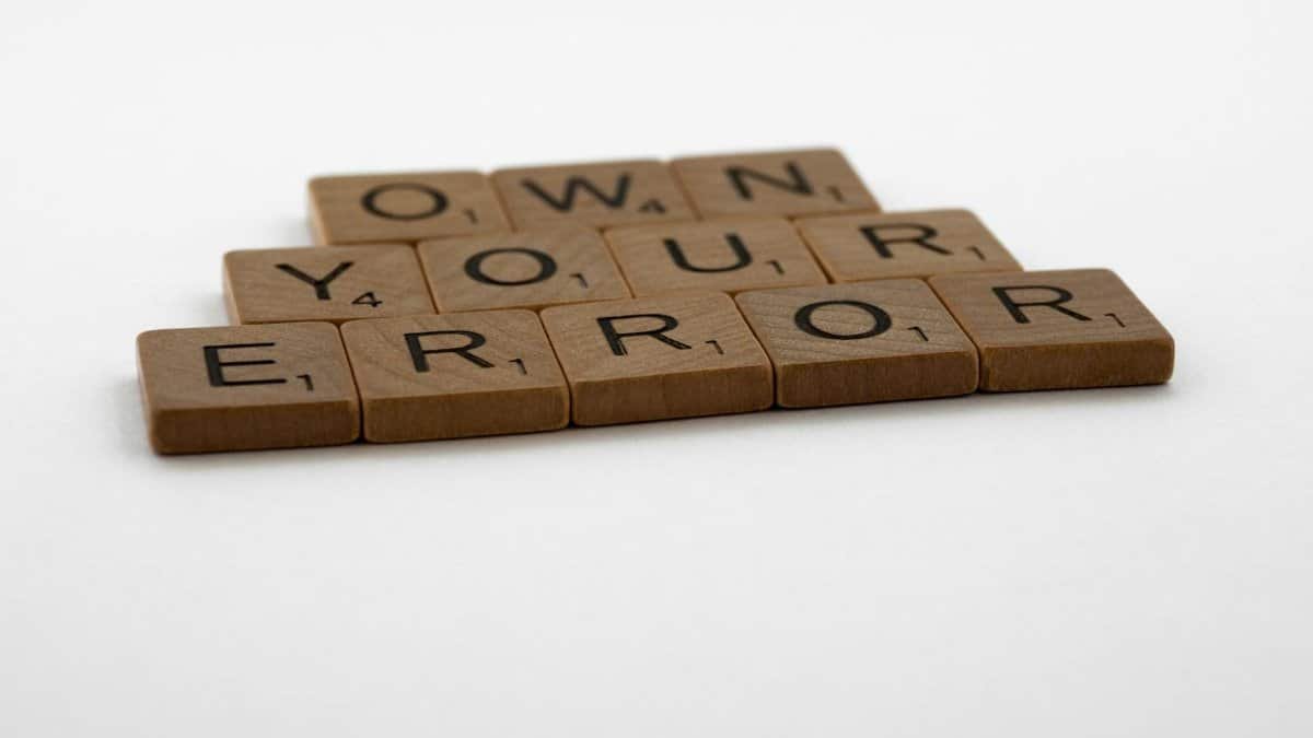 A motivational phrase assembled with Scrabble tiles on a white background.