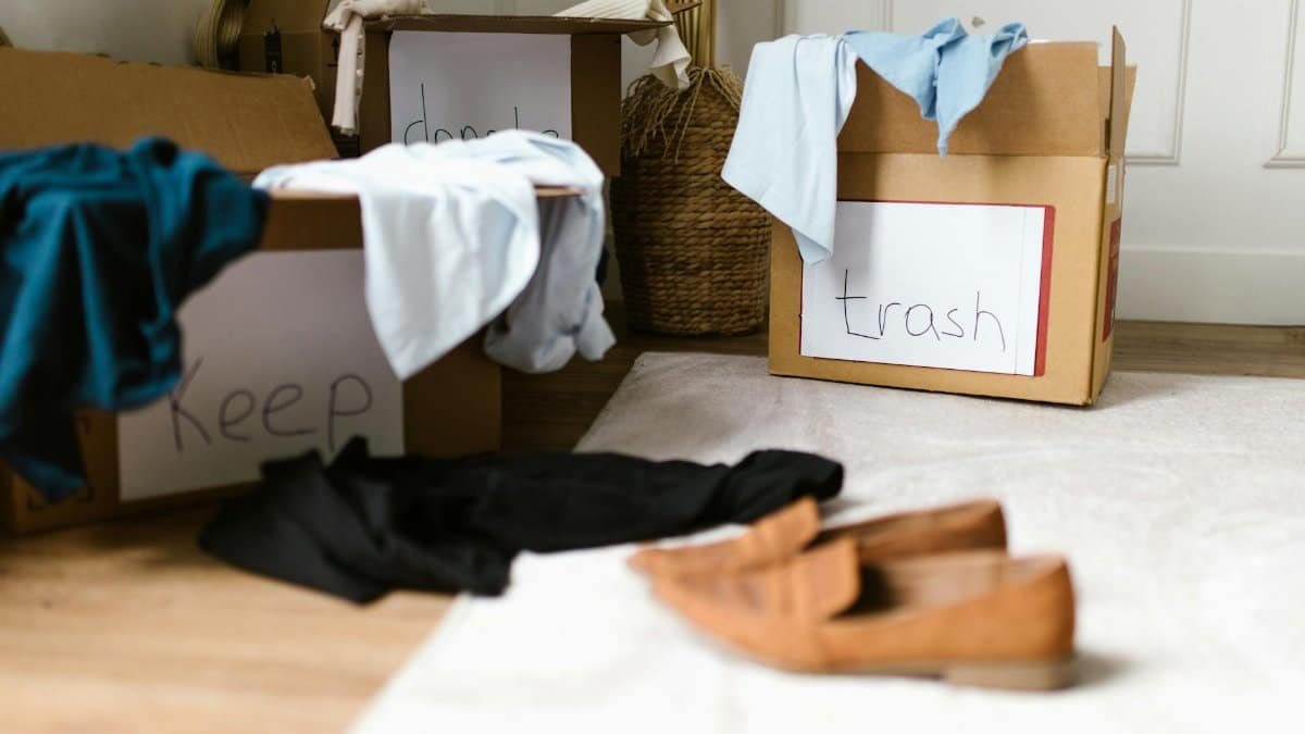 Decluttering concept using labeled boxes for sorting clothes in a home setting.