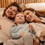 A joyful family bonding together while lying in bed, creating precious moments.