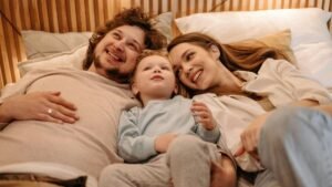 A joyful family bonding together while lying in bed, creating precious moments.