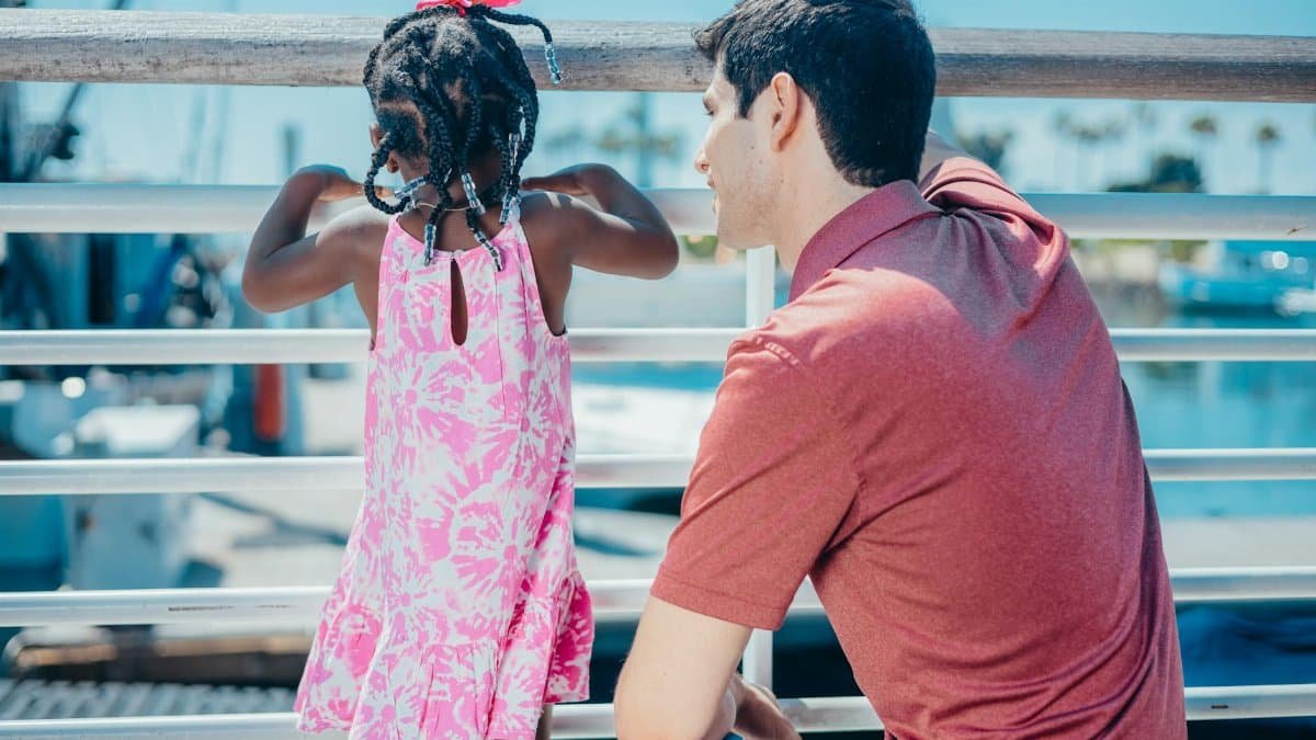Man and young girl enjoying quality time together on a sunny day by the water.