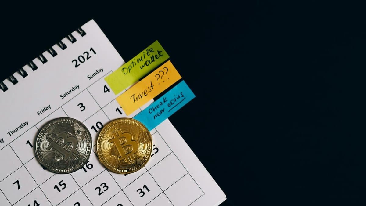 Close-up of Bitcoins on a calendar highlighting investment plans with sticky notes.