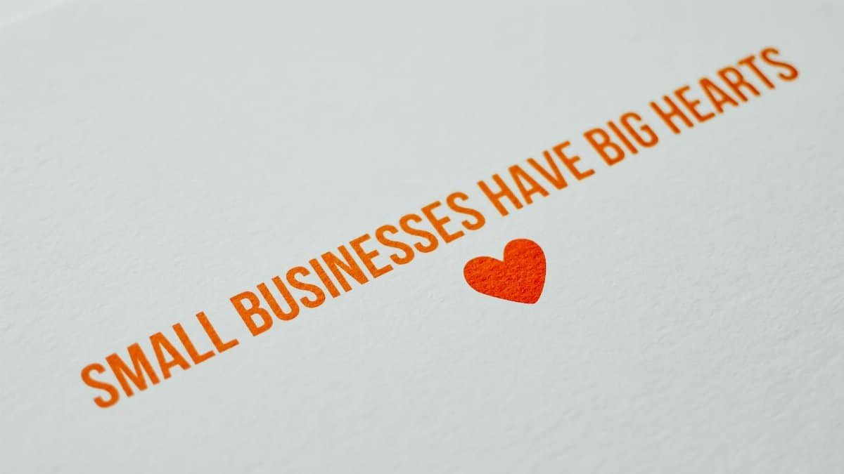 Close-up of motivational text: Small businesses with big hearts on paper.