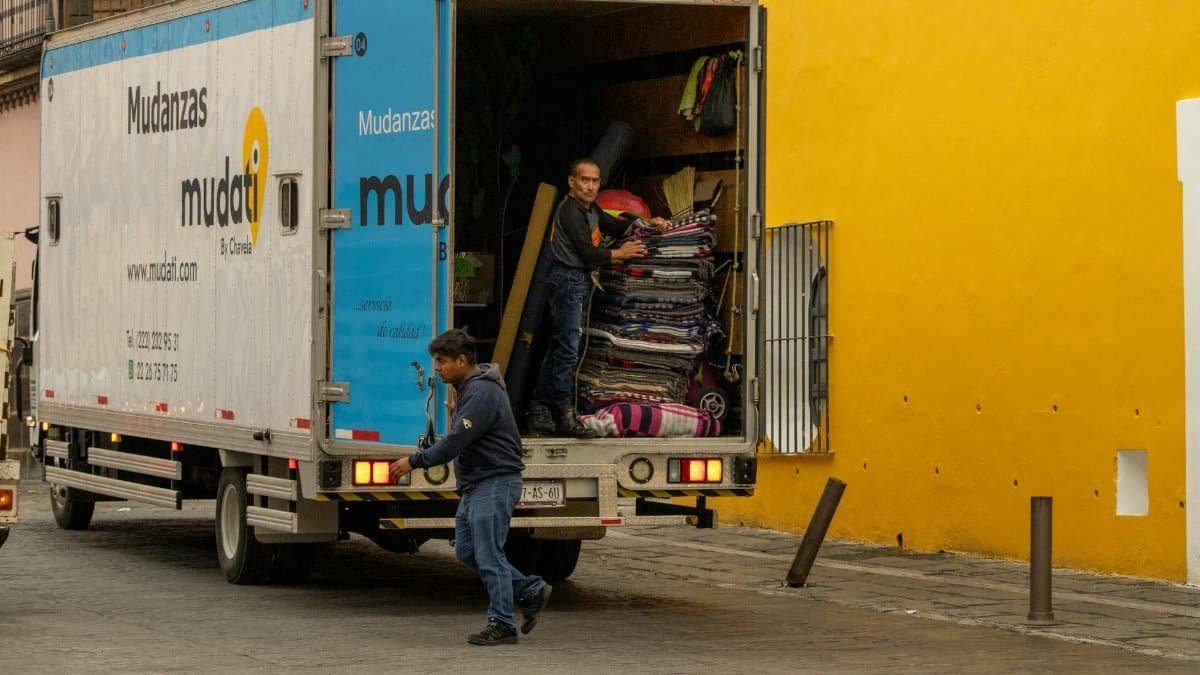 Workers loading a moving truck on a street in Mexico, urban lifestyle.