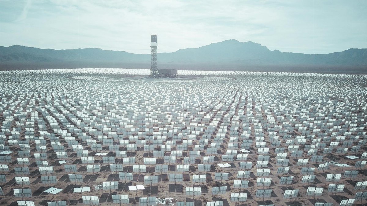 Expansive solar farm with hundreds of panels in a desert landscape, harnessing renewable energy.