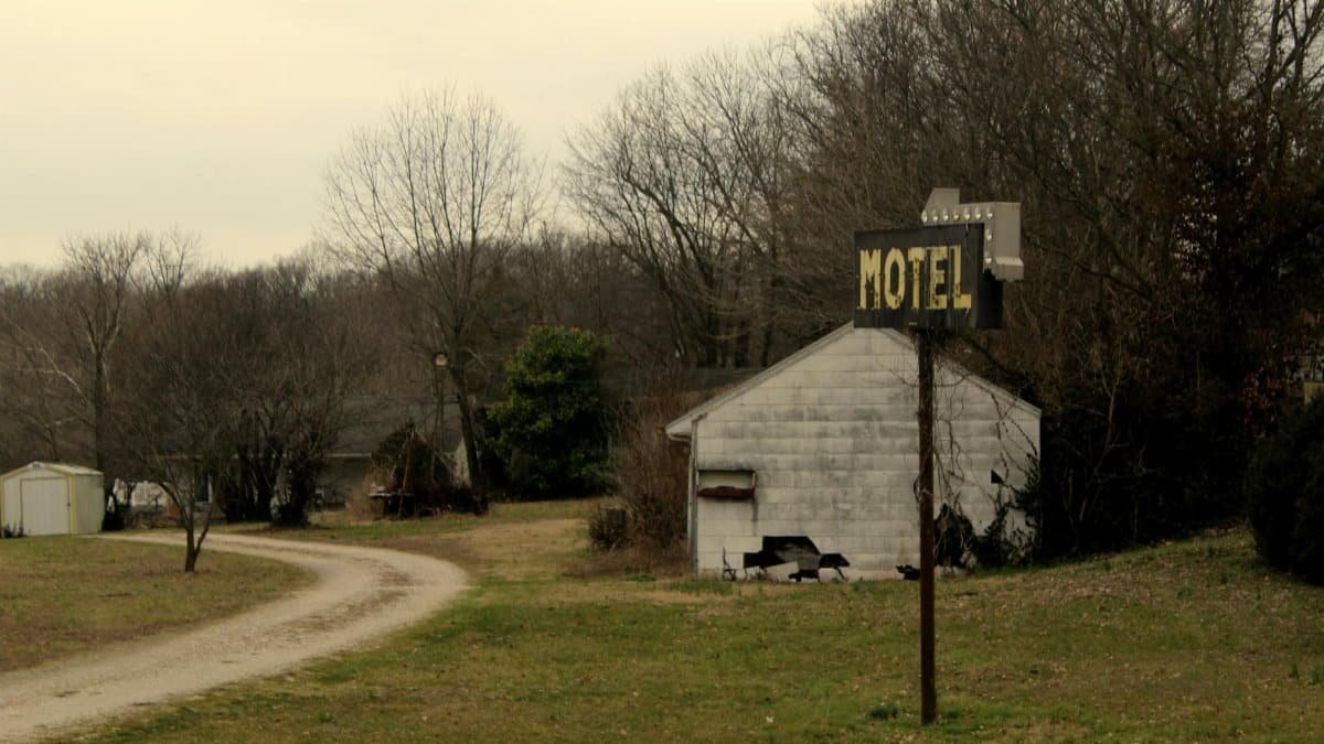 Old motel sign on a dirt road in rural Missouri, USA.