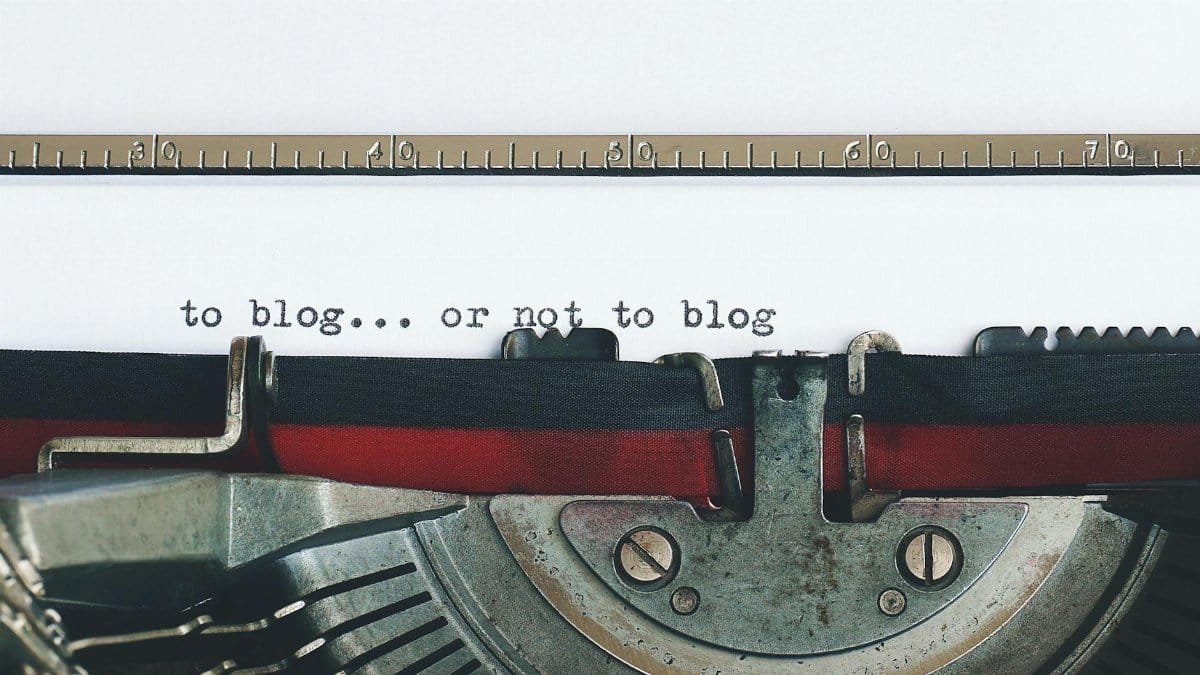Classic typewriter with 'to blog or not to blog' typed on paper.