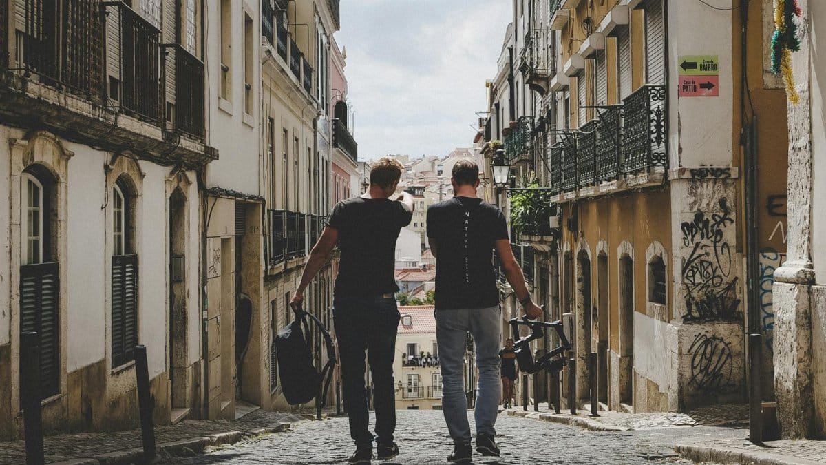 Two friends walking through Lisbon's charming cobblestone streets, capturing the urban vibe.