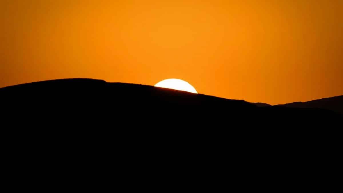 Stunning silhouette of a mountain ridge during a vibrant sunset with a glowing sky.