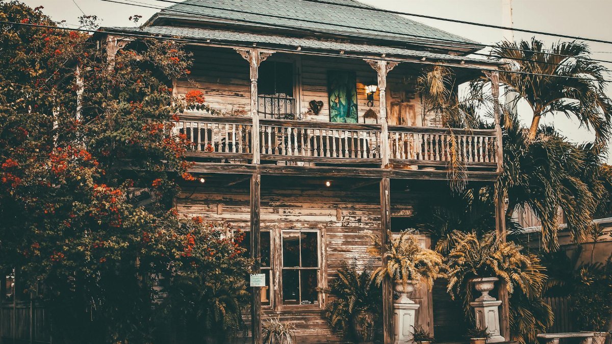 Explore a rustic vintage wooden house surrounded by tropical foliage in Key West, FL.