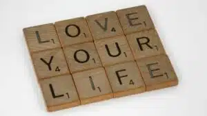 Scrabble tiles arranged to spell 'Love Your Life' against a white background, conveying a positive message.
