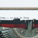 Classic typewriter with 'to blog or not to blog' typed on paper.