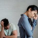 An Asian woman and man feeling misunderstood and frustrated in a relationship indoors.
