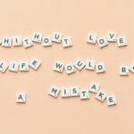 Scrabble tiles forming the phrase 'Without love life would be a mistake' on a beige background.