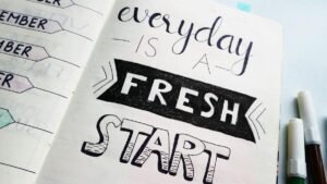 Notebook page featuring motivational quote 'Everyday is a fresh start' with colorful pens.