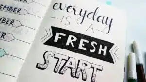 Notebook page featuring motivational quote 'Everyday is a fresh start' with colorful pens.